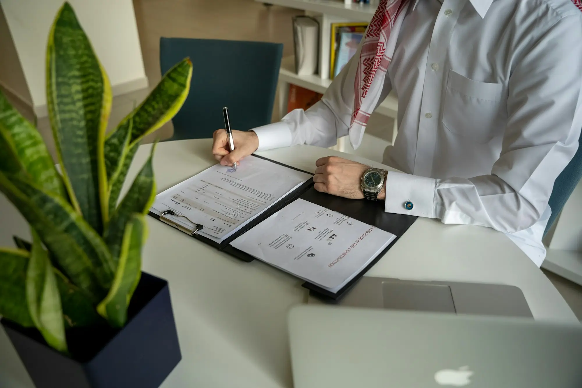 Business owner at a desk making notes while reviewing a loan offer