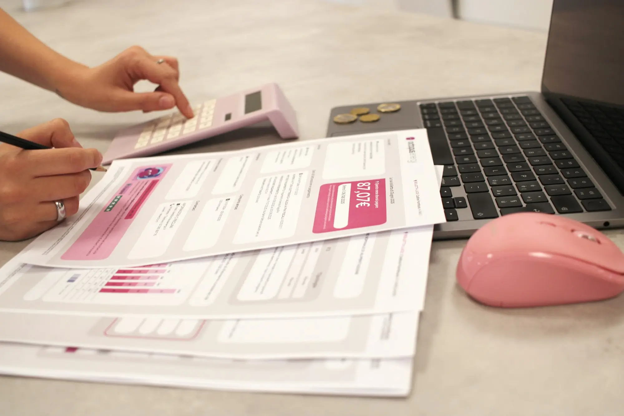 Small business owner working through bills with a calculator