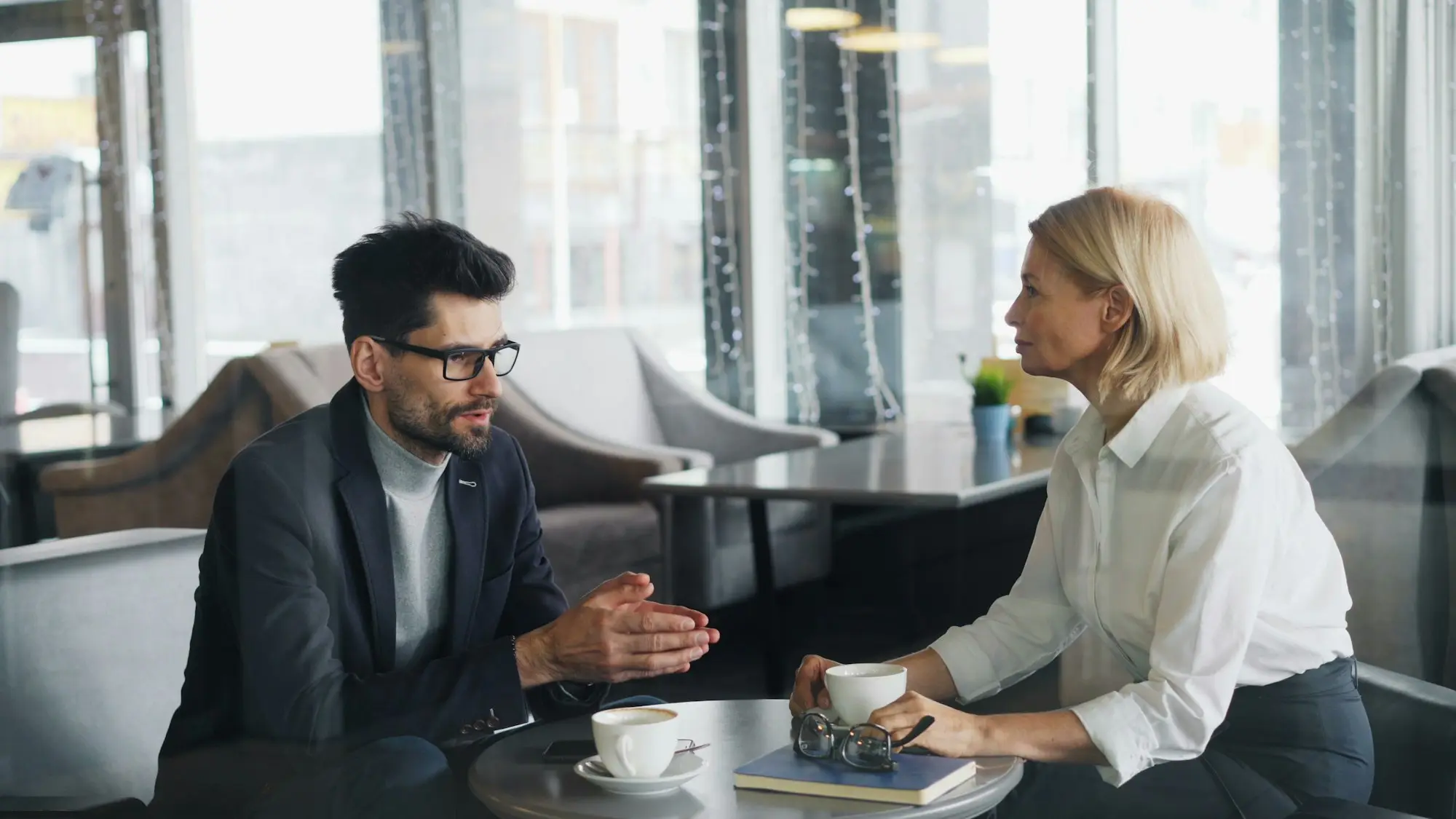 Two business owners talking over a decision at a table